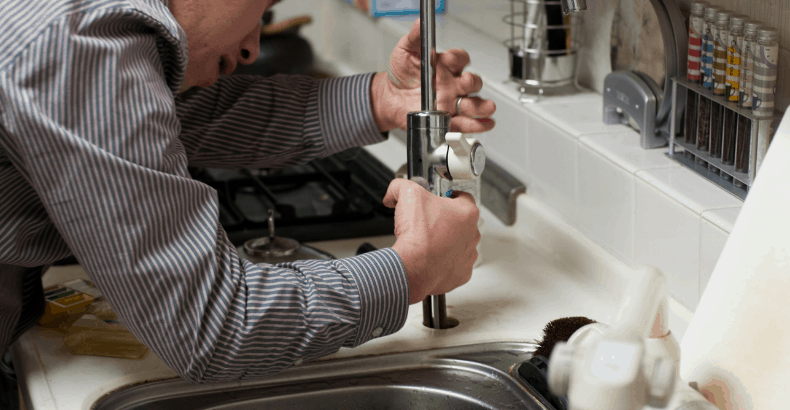 Man trying to fix kitchen sink