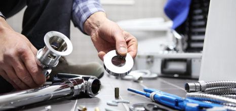 Plumber with tools in bathroom