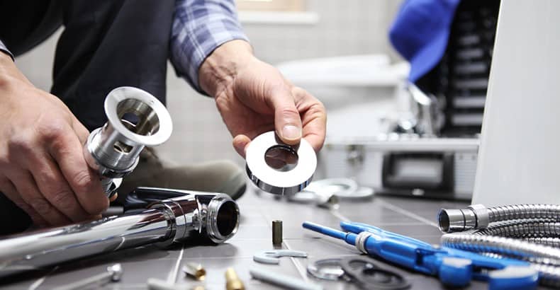 Plumber with tools in bathroom