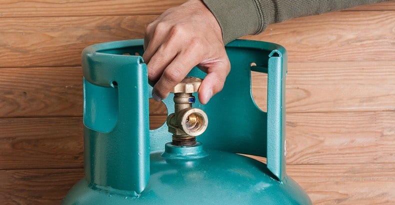 hand turning on blue-green gas cannister