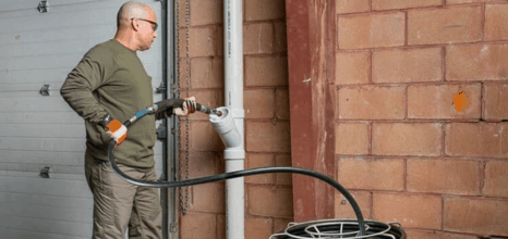 Man using robot cutter to clean pipes