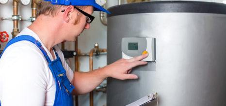 plumber in overalls reading gas meter