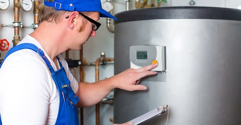 plumber in overalls reading gas meter